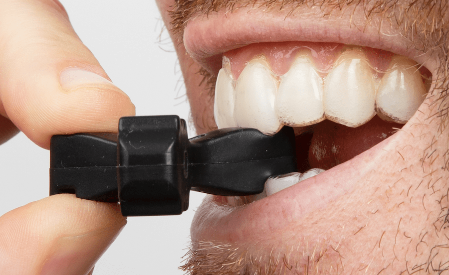 Side, close-up view of Munchies® Maintain engaged with lower central incisor