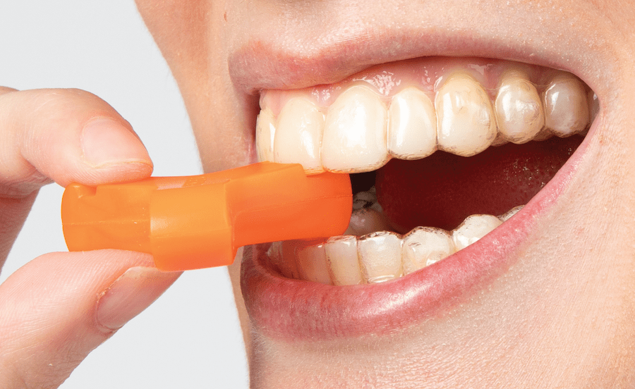 Side, close-up view of Orange Munchie engaged with incisor